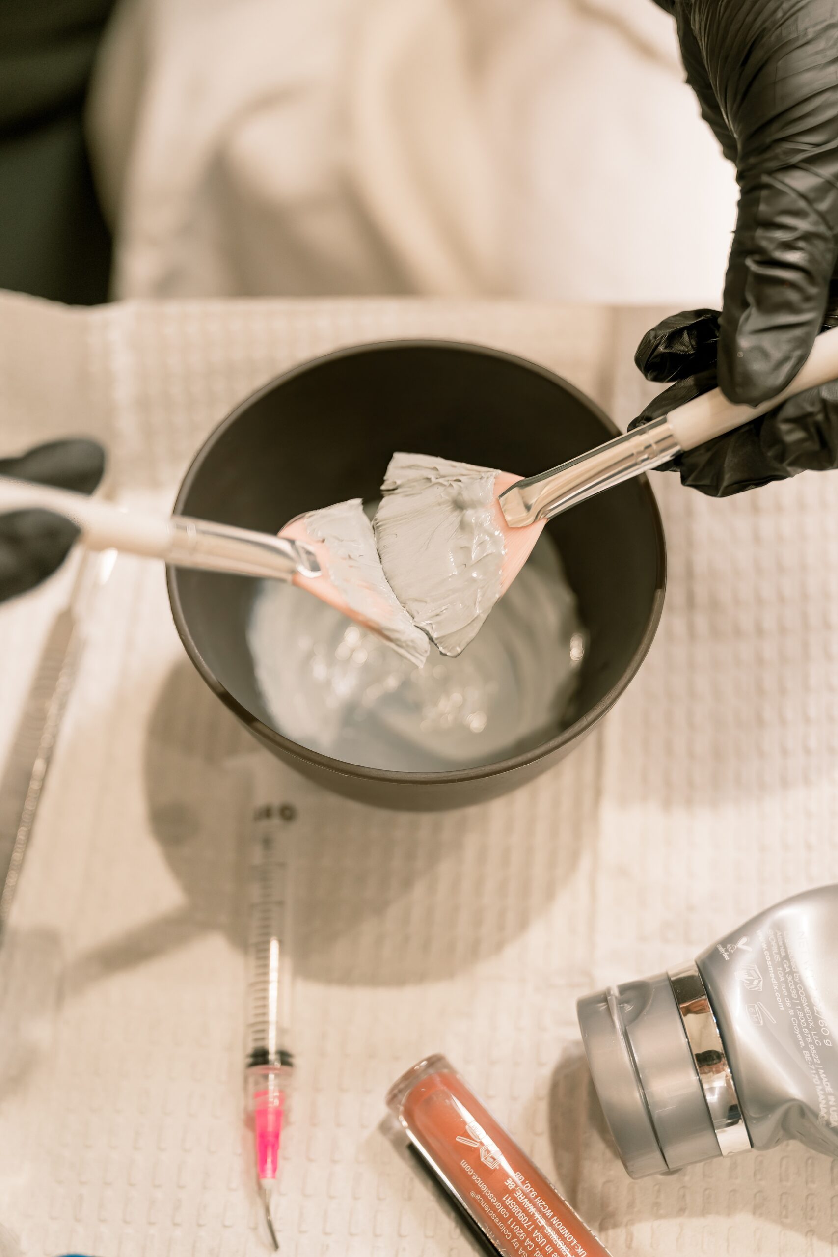 Details of someone mixing a chemical with brushes when showing the difference between stock photos vs real photos