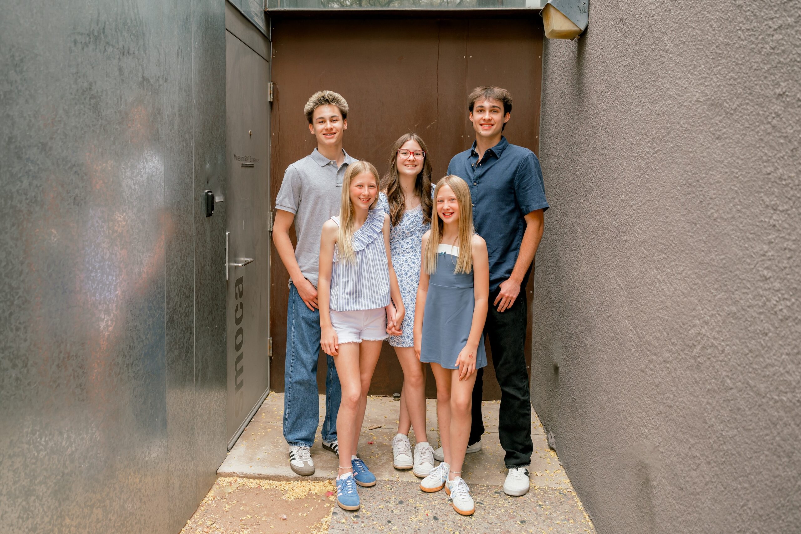 A group of kids standing behind the library in old town scottsdale for a family photo shoot.